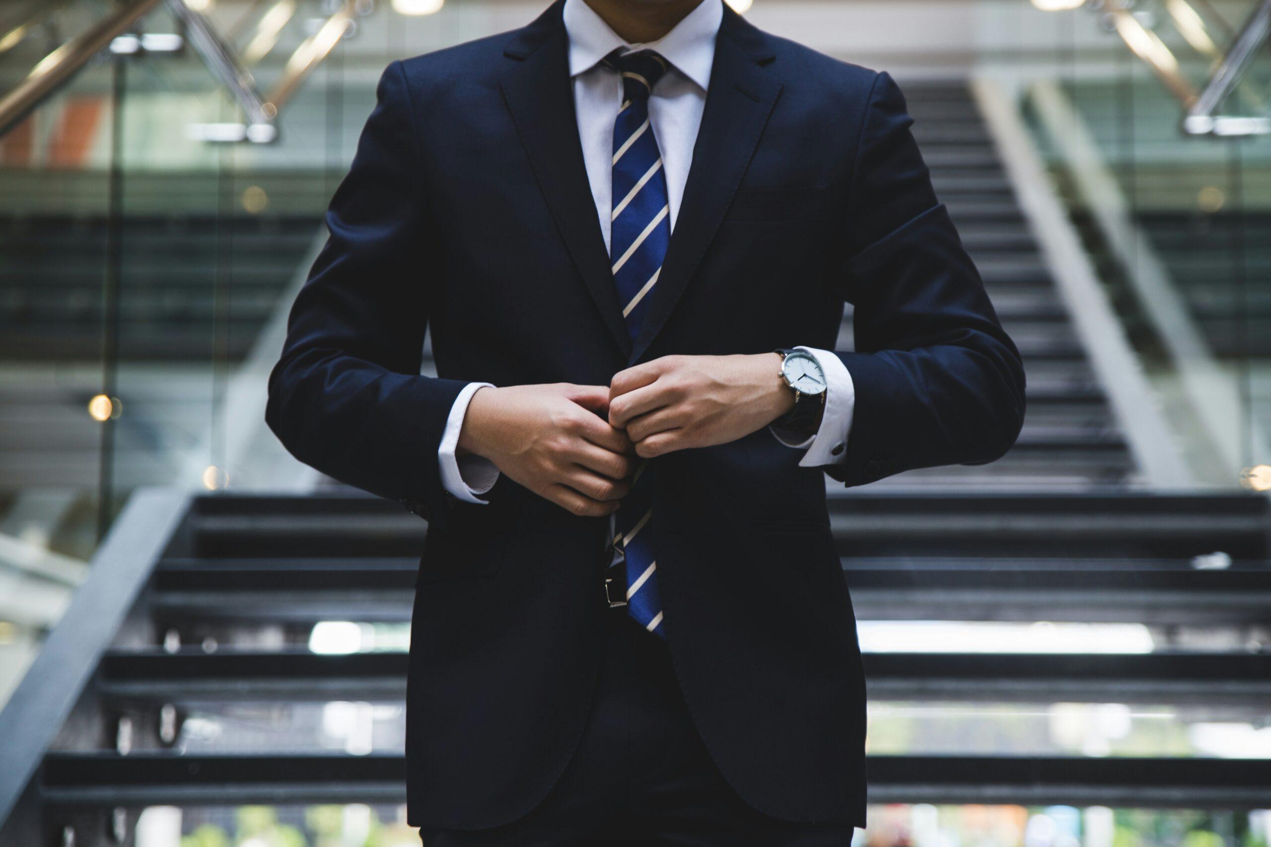 A confident professional in a formal suit adjusting their jacket, symbolizing success, leadership, and corporate professionalism.