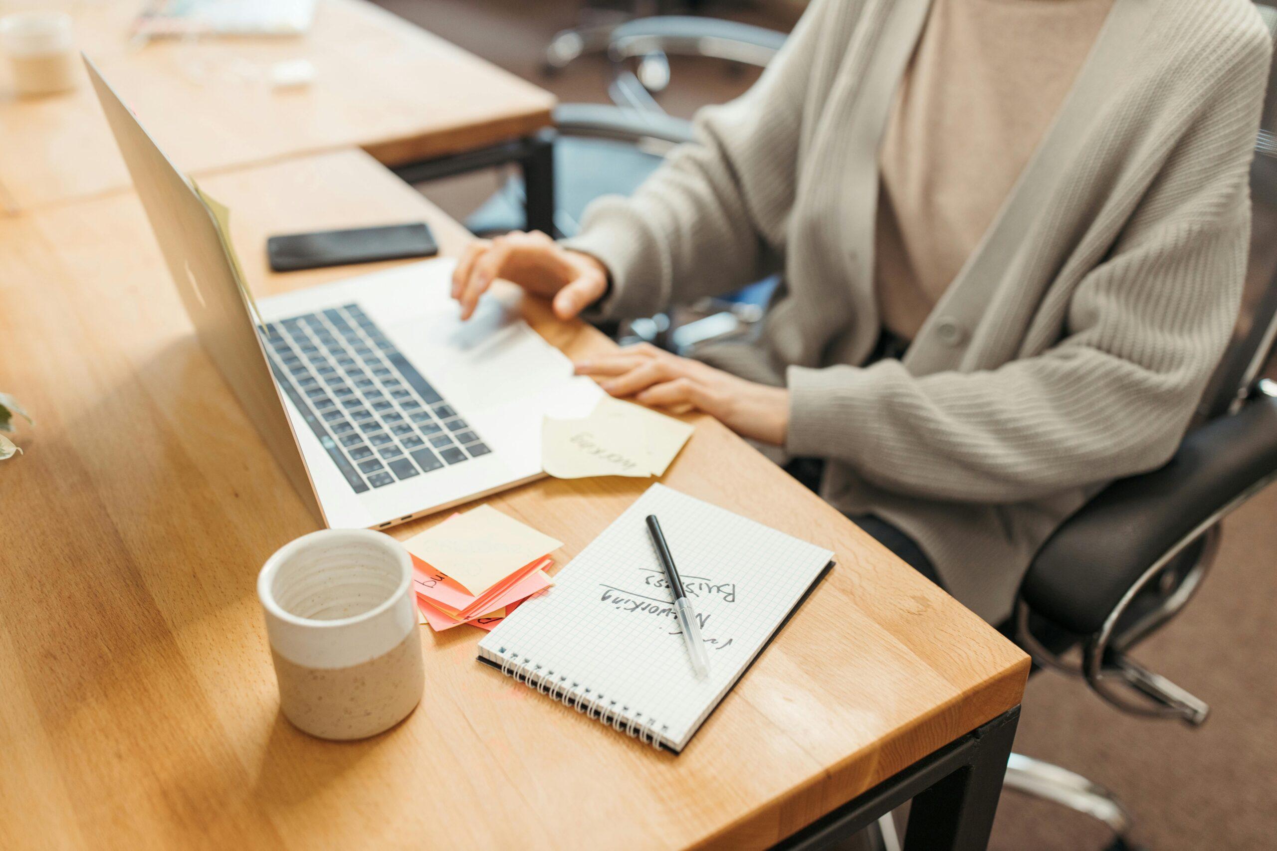 Event planner organizing tasks on a laptop with notes and a checklist for efficient Event Planning