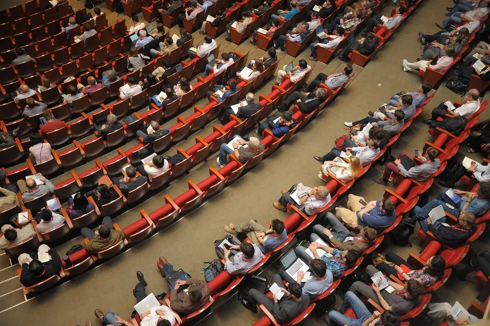 Corporate event in a large auditorium, with a full audience ready for a corporate meeting.