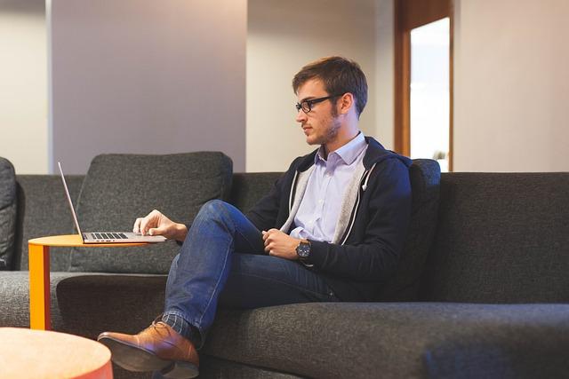 Employee sitting on sofa and attending a virtual event